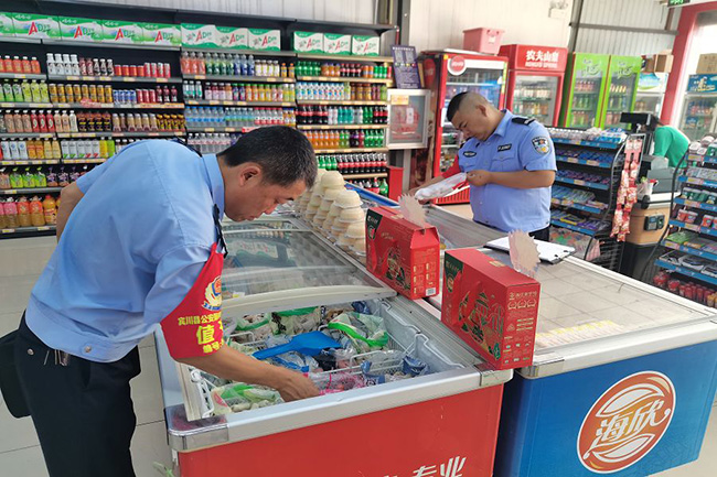 民警在農貿市場內檢查食品安全。