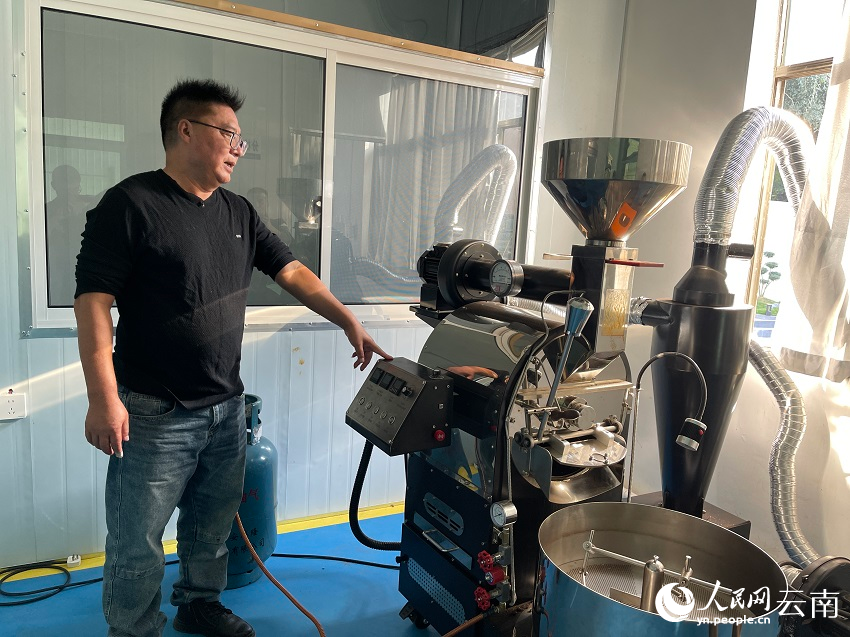 陈罡介绍公司研发生产的咖啡加工设备。人民网记者 程浩摄
