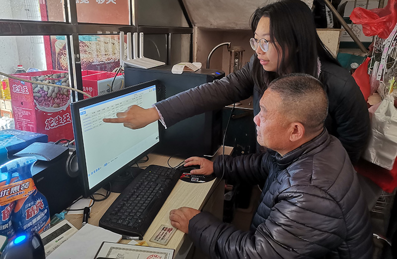 客户经理邓雅丹指导客户操作零售终端管理系统。王涵摄