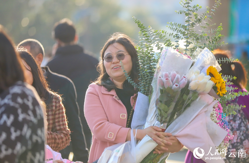 2月2日下午，一位市民抱著心儀的年宵花走出昆明斗南花卉市場。人民網記者 虎遵會攝