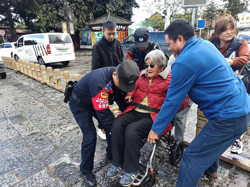 民警帮老人抬轮椅。