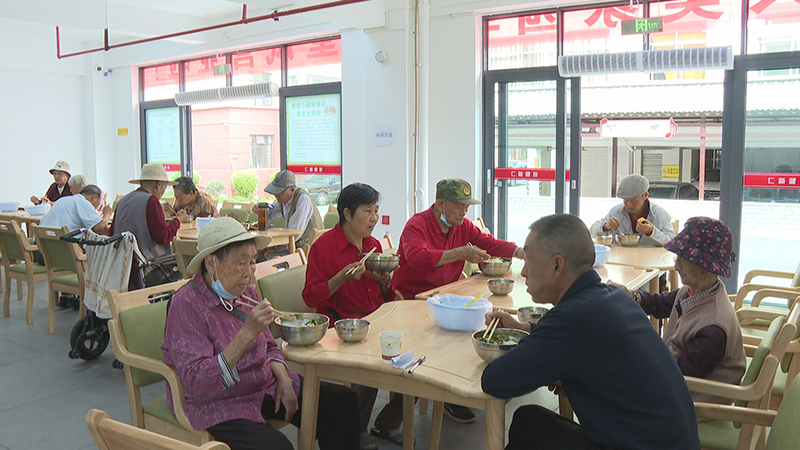 共美家园幸福食堂里，老人们欢聚在一起享用午餐-。（罗扬摄）