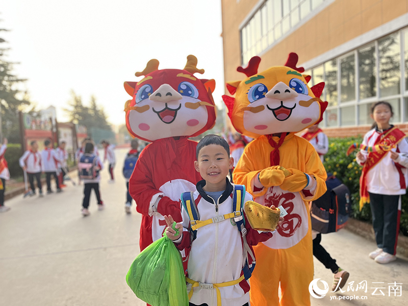 安宁市第一小学学子展笑颜，与“小龙人”合影。贾建荣摄