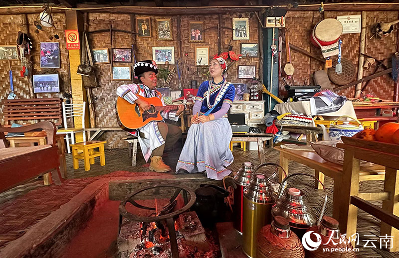 江晓春与妻子张晓慧围着火塘弹唱《老姆登之夜》。人民网曾智慧摄