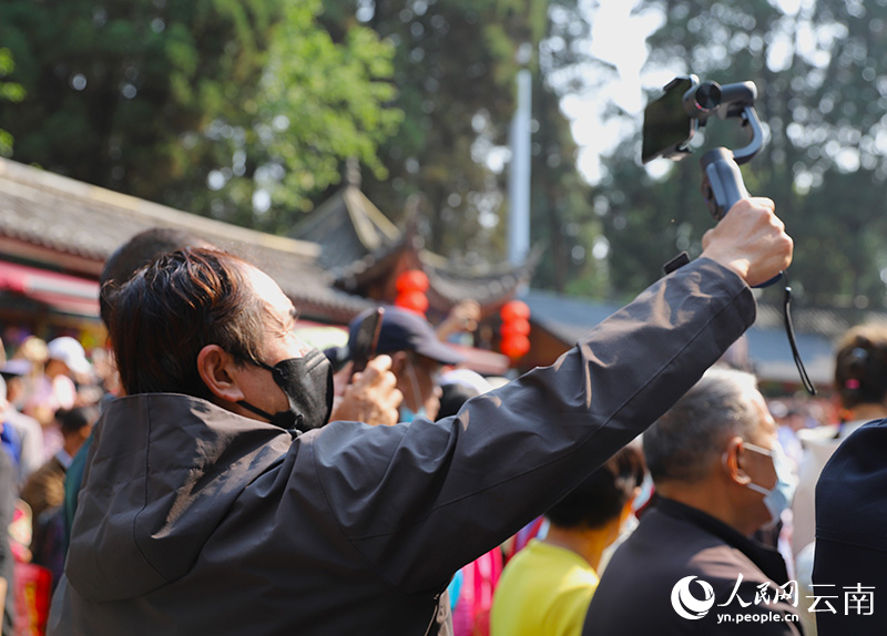 雲南民歌表演吸引市民游客舉起手機拍攝。人民網 尹馨攝