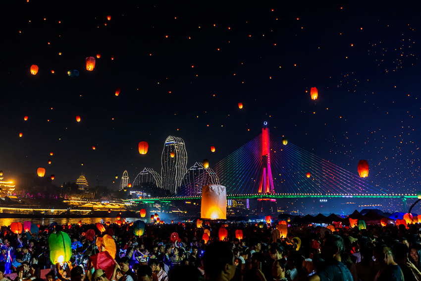 夜空中的孔明燈與霓虹燈光交相輝映。陳暢攝