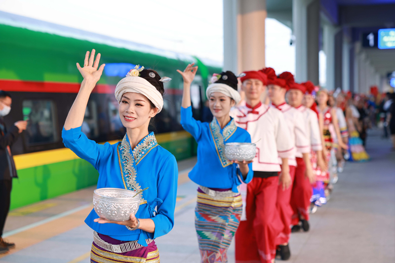【图2】4月13日，在西双版纳站，工作人员欢迎乘坐中国西双版纳至老挝琅勃拉邦首发列车的旅客。陈畅摄.jpg
