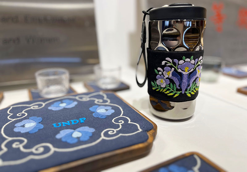 【图3】“彝礼还潮”展厅里展出的彝绣文创杯套、杯垫。人民网-尹馨摄