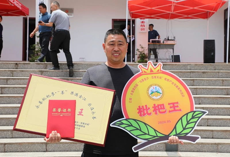 永善县玉笋山庄负责人王仁海领取“枇杷王”荣誉证书。-永善县融媒体中心供图