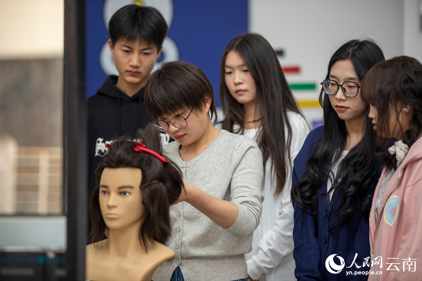 3李红艳正在给学生演示剪发技巧。人民网记者 符皓摄