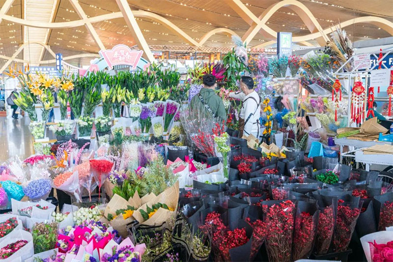 暑运期间，旅客在昆明机场航站楼选购云南鲜花。