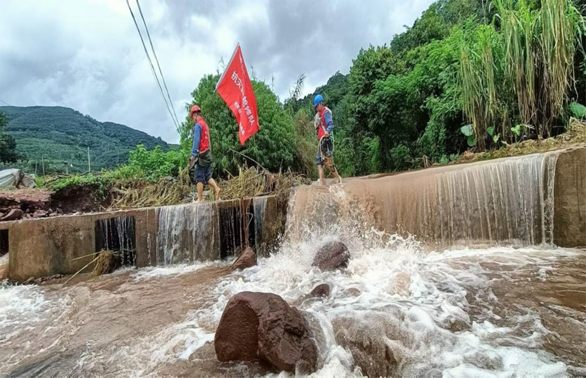 磨憨供電所黨支部黨員突擊隊涉水前往受災現場進行搶修作業。岩鳳攝