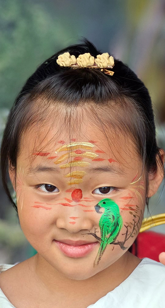今年8月的一次活动中，彩绘师在一名小孩子脸上绘的小鸟。马街镇政府供图