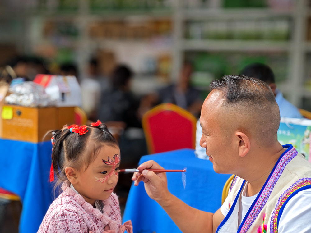 今年8月的一次活动中，彩绘师在一名小孩子脸上绘的小鸟。马街镇政府供图