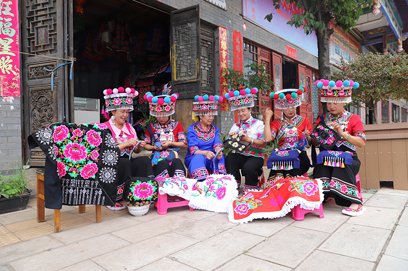 丁会芝（右三）正在教绣娘们刺绣。孔应秀摄