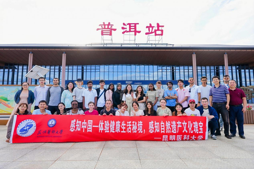 参加“感知中国”社会实践和文化体验活动的留学生们在普洱火车站前合影。昆明医科大学供图