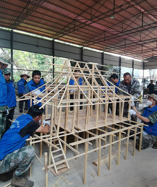 群众在学习傣楼建造方法。景洪市人力资源和社会保障局供图