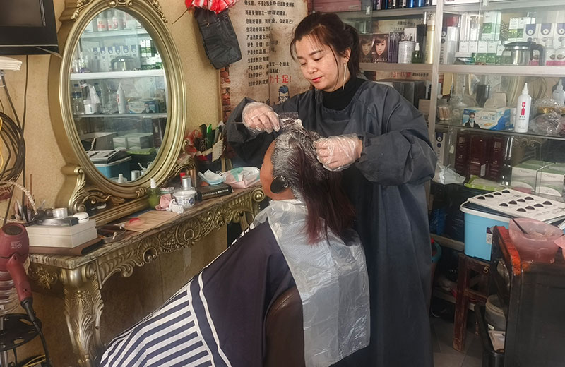 张蓉为到店的老人染发。简旭丹摄