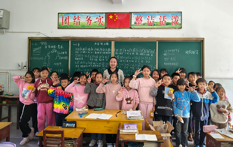 一堂音乐课后，罗巧和学生们合影。镇沅县融媒体中心供图