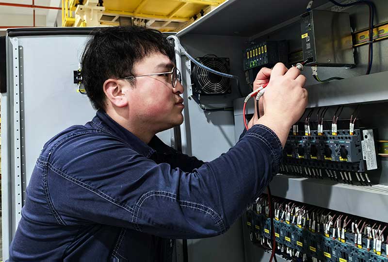 周书冲检查电控柜。朱泽排摄