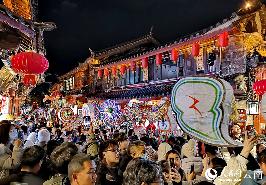 元宵節當晚，麗江市民身著民族盛裝，手提傳統手工花燈，和游客一起在古城大街小巷巡游賞燈。和儉攝