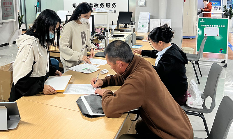 办证人员指导申请人办理申请手续-勐海县局(分公司)夏君桔摄