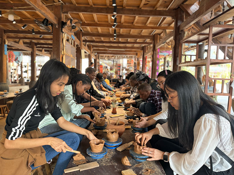 中外游客体验傣陶制作工艺