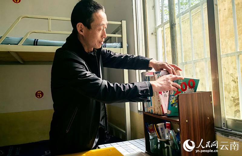 王国广为学生们整理书桌。莫娟摄