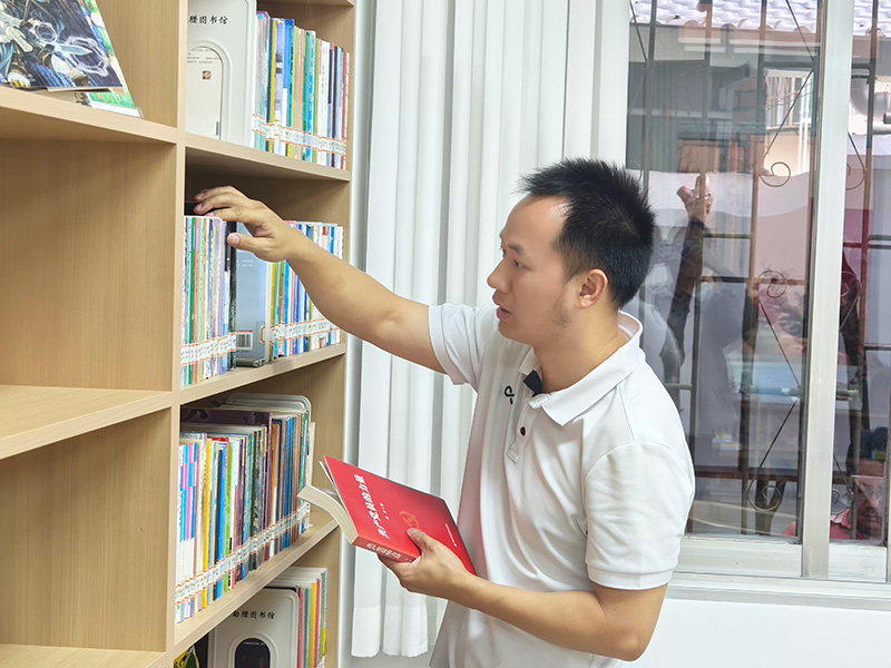在书架上挑选自己喜欢的书籍（张永军摄）
