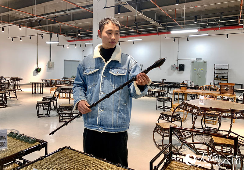 周欽正在查看制作好的筇竹拐杖。人民網 王嫻攝