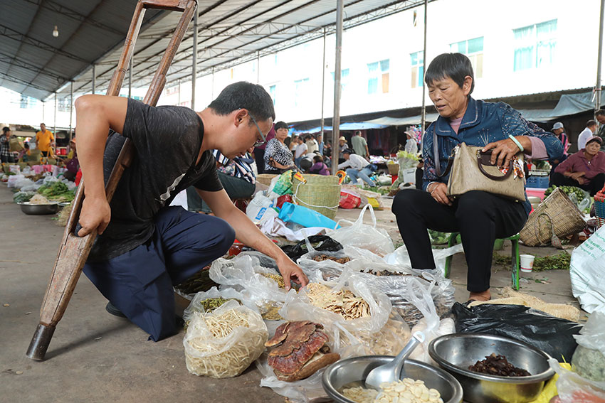 李红富在农贸市场采购农产品。杨廷荣摄