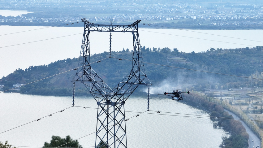 雲南電網採用無人機清洗帶電輸電線路絕緣子。雲南電網供圖