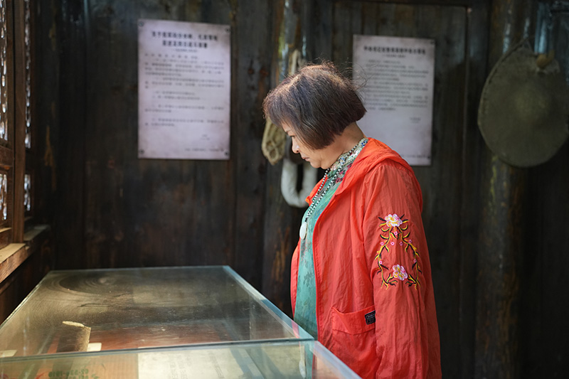 在花房子会议旧址，老人仔细观看展柜中的历史资料