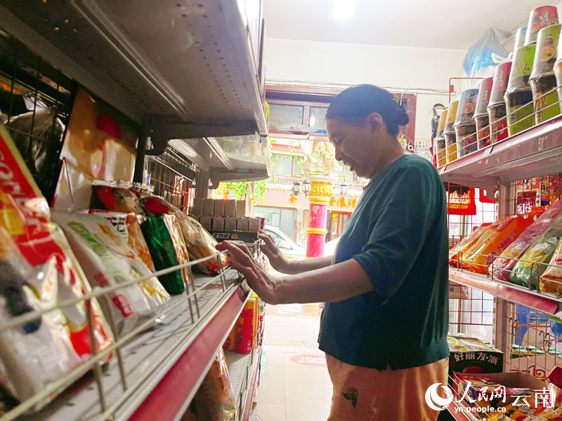 阳代琼正在整理货架。人民网记者 程浩摄