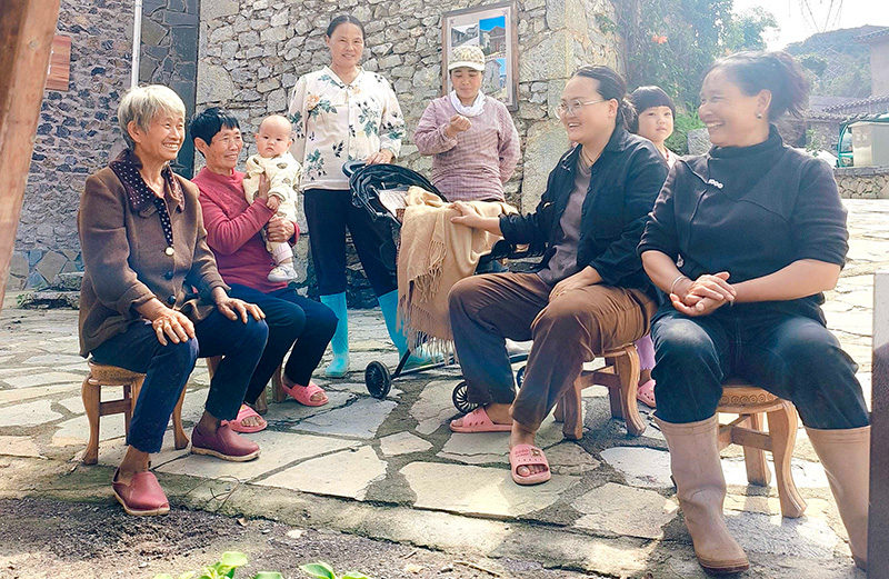 村民们在便利店的休息区乘凉聊天。--谢卓言摄