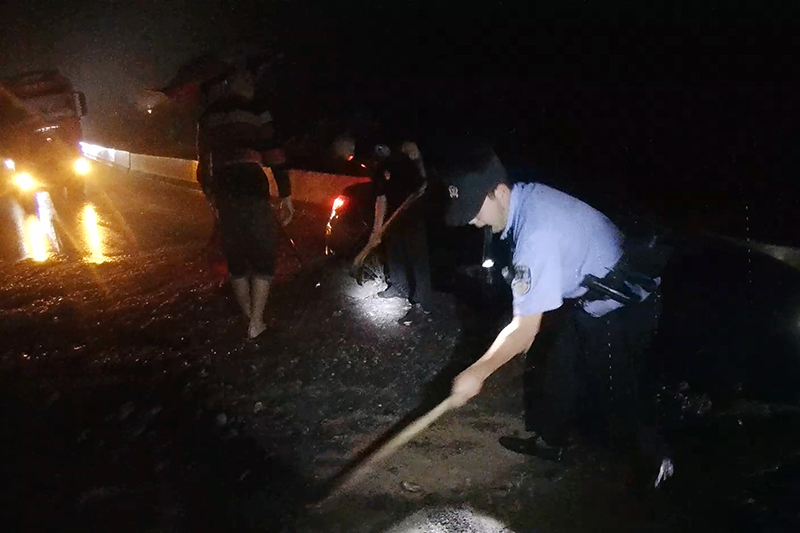 1民警在清理路面泥沙。昭通市公安局供图