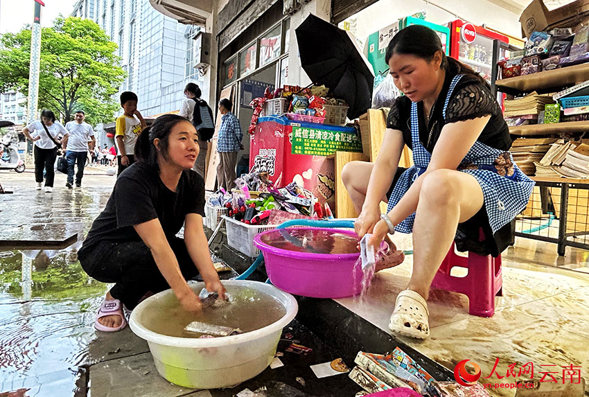 暴雨過后，威信縣的干部群眾紛紛走上街頭，齊心協力開展清淤清障、商品貨物清洗等工作。人民網記者 劉怡攝