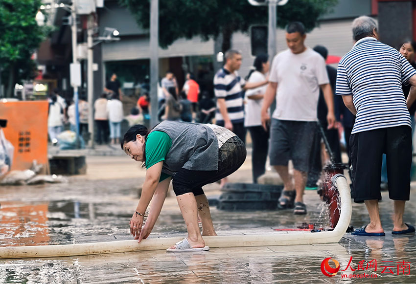 暴雨過后，威信縣的干部群眾紛紛走上街頭，齊心協力開展清淤清障、商品貨物清洗等工作。人民網 尹馨攝