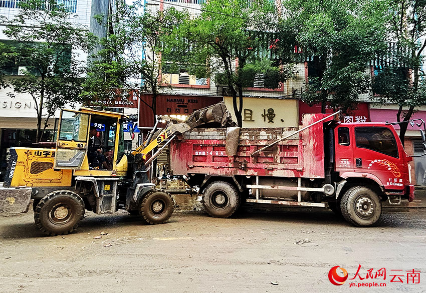 暴雨过后，威信县的干部群众纷纷走上街头，齐心协力开展清淤清障、商品货物清洗等工作。人民网记者 刘怡摄