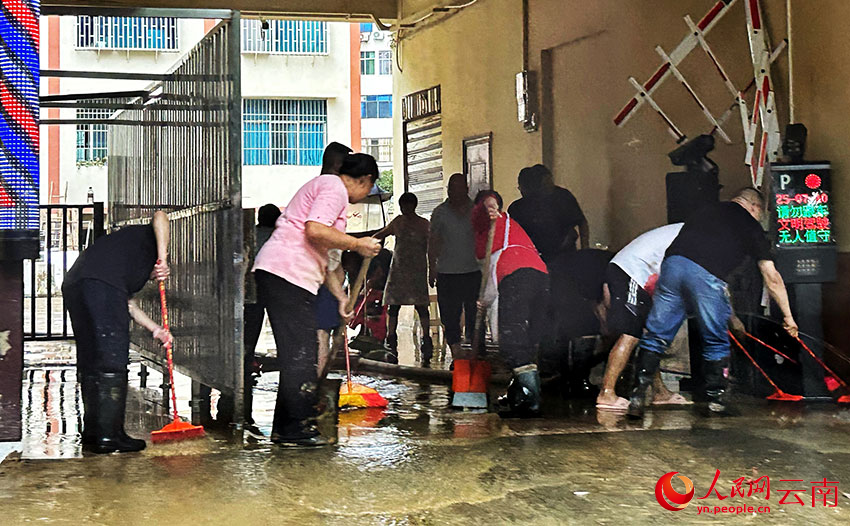 暴雨过后，威信县的干部群众纷纷走上街头，齐心协力开展清淤清障、商品货物清洗等工作。人民网记者 刘怡摄