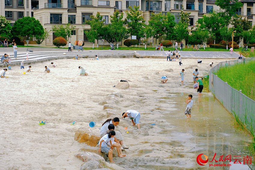 孩子們正在烏蒙水鄉公園的沙灘區域玩耍。曾智慧攝