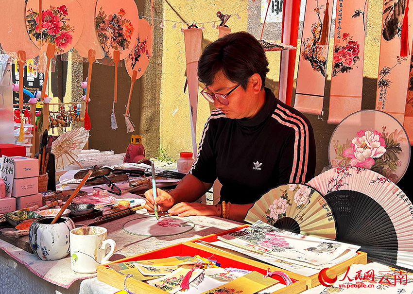 在糖行街特色集市上，一名摊主正在创作。人民网记者 刘怡摄