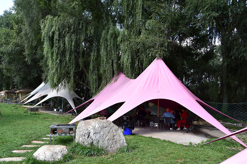 游客在云南昭通昭阳洒渔河岸的烧烤区边吃边娱乐。任天能摄