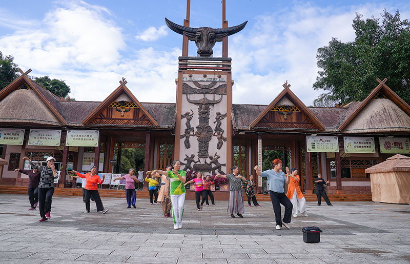 勐梭龍潭公園門口,老年人正練習太極拳。奚川江攝