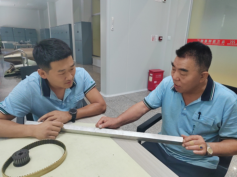 李长名（右）与徒弟王全福在探讨维修方案。吕世华摄