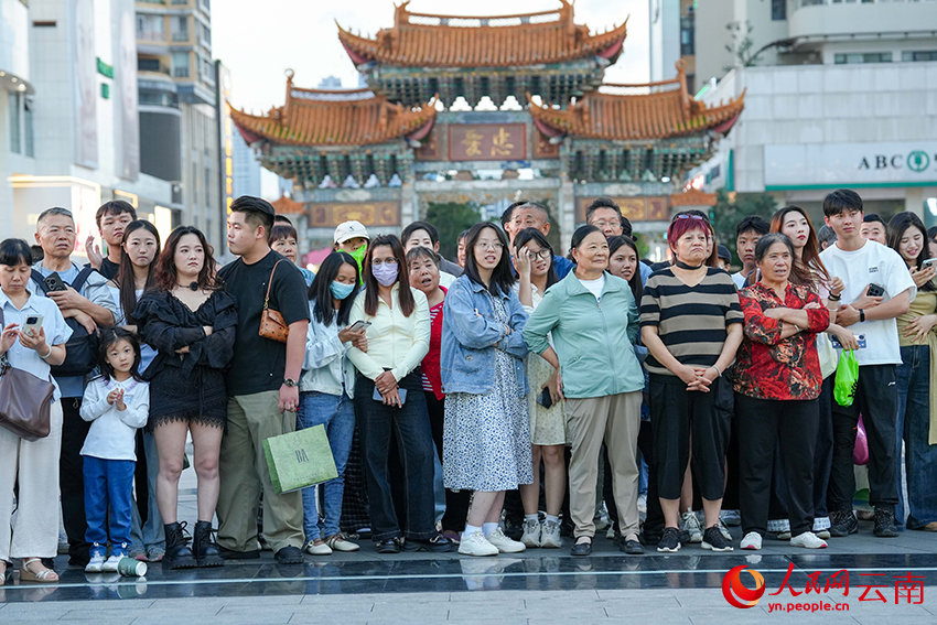 现场的佤族织锦快闪秀表演吸引众多市民驻足观看。人民网记者 虎遵会摄