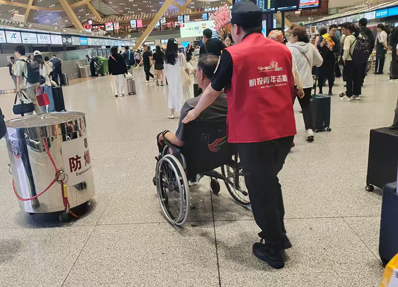 志愿者为特殊旅客服务。