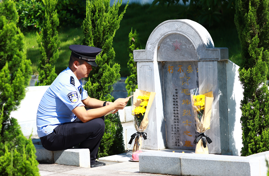 【图8】图为民警在收到信件后第一时间前往毛炜烈士墓碑前读信。