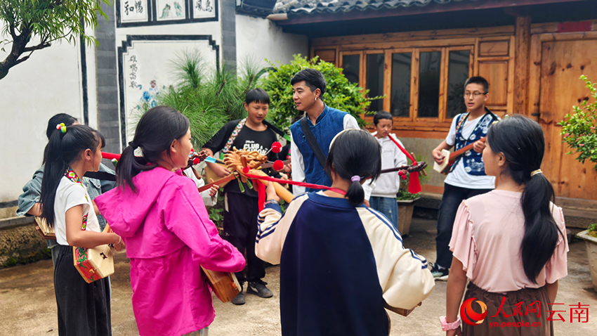 3董祿龍正在教村裡的小孩彈唱。人民網記者 符皓攝