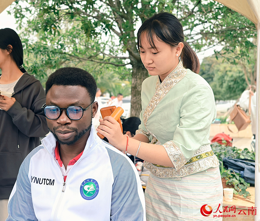 留学生体验傣式锤筋。人民网 尹馨摄